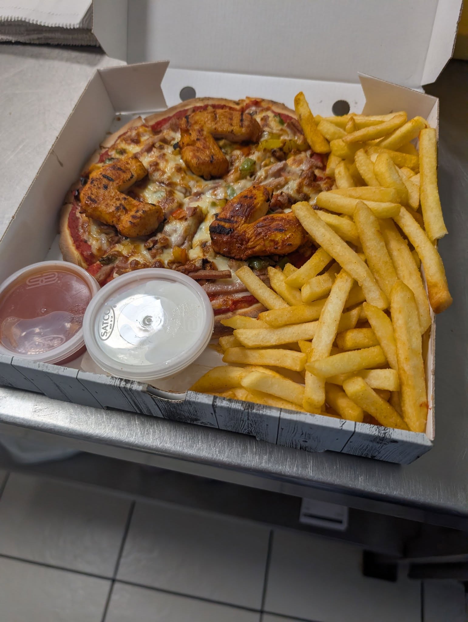 Pizza share box with grilled chicken wings and seasoned fries