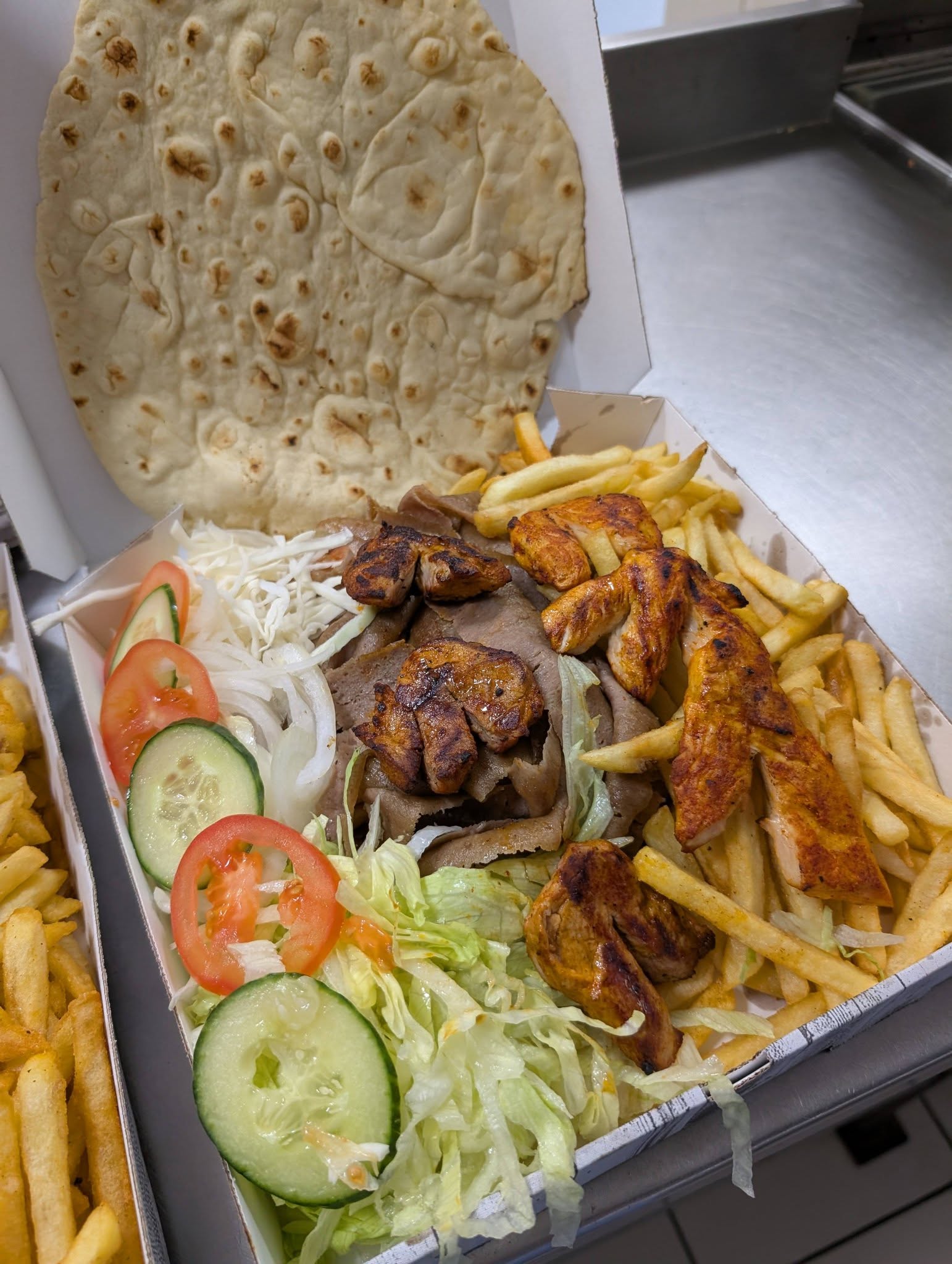 Share box with grilled chicken pieces, doner meat and fresh salad